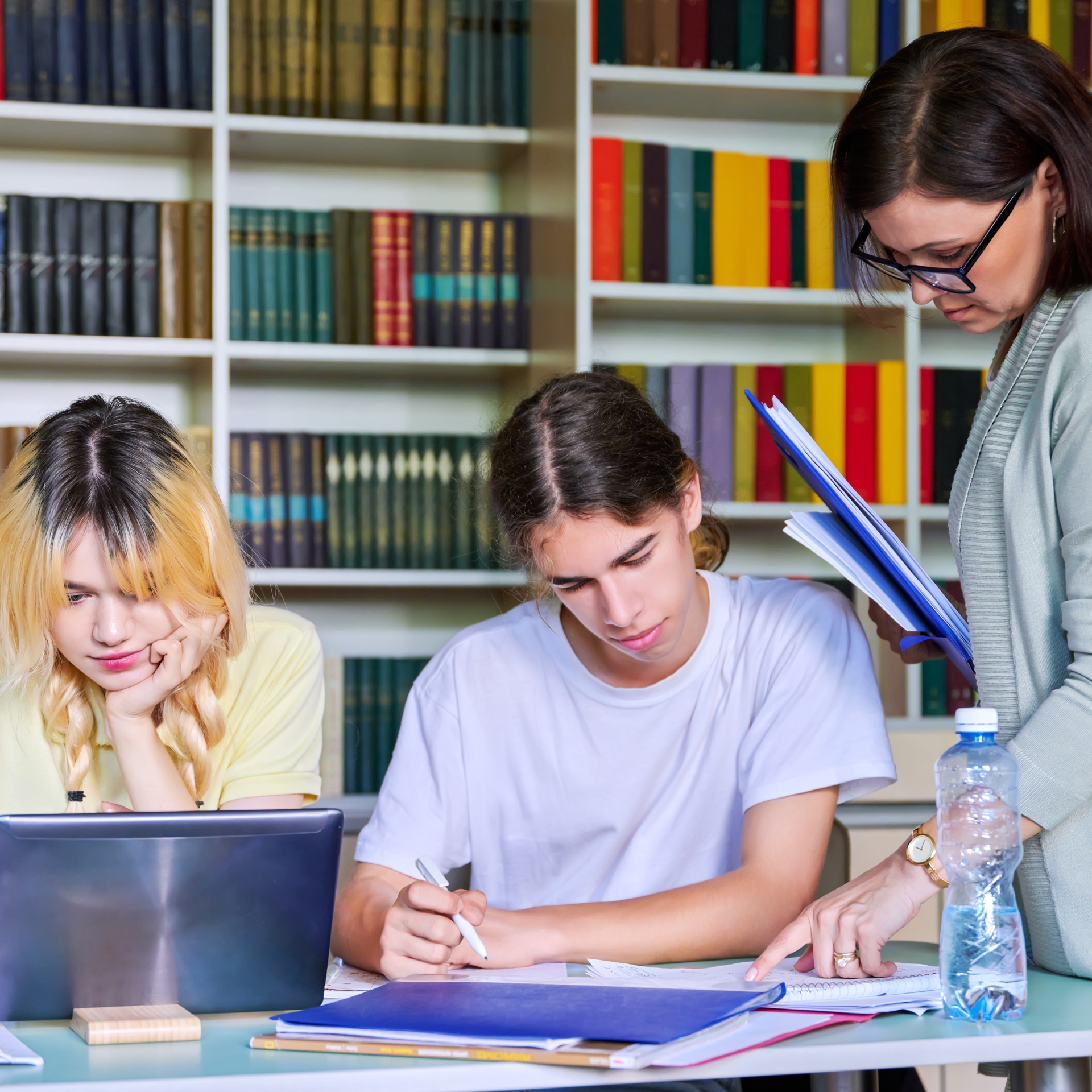 55224012 Girls Teenage Students Studying In Library With Teacher