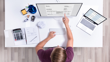 32616673 Businessman Checking Invoice On Laptop